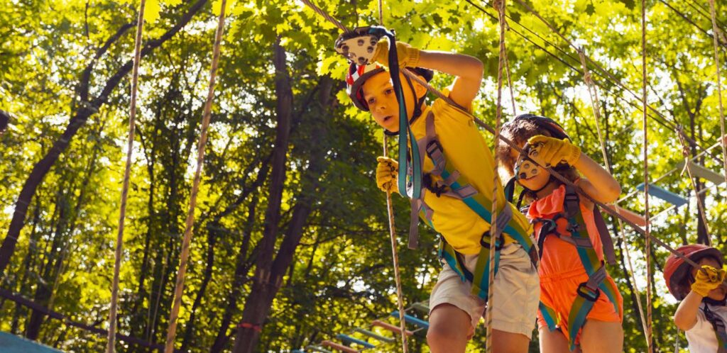 The concentrated kids are climbing in the high rope park